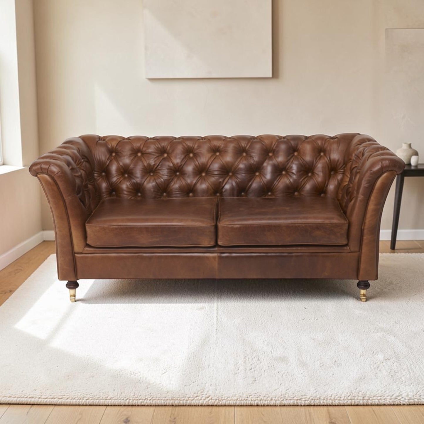 A Cerato brown leather Chesterfield sofa with tufted button detailing, shown in a bright living room setting on a white rug.