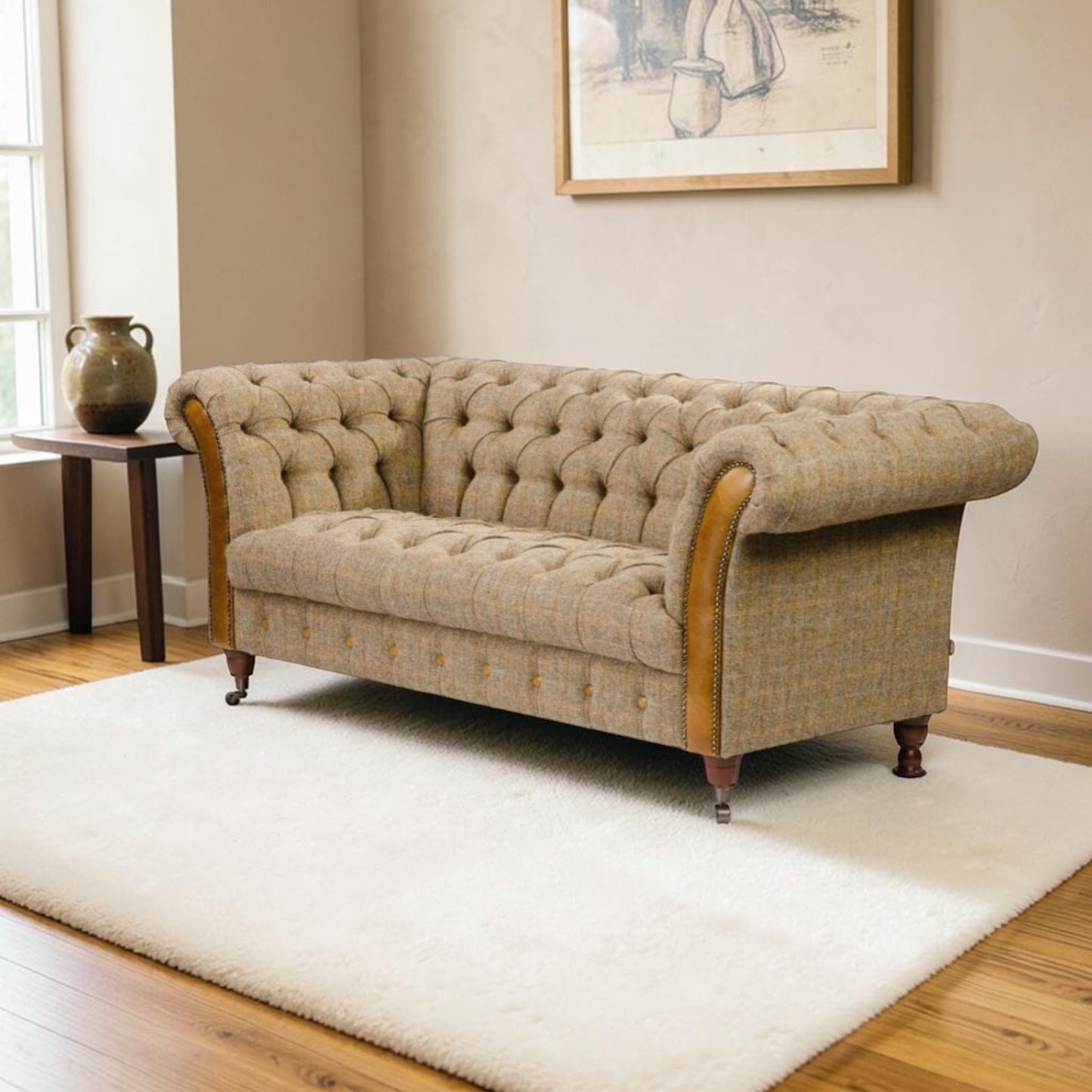 A classic Chesterfield sofa upholstered in a textured beige tweed fabric with brown leatherette arms and legs, set on a white shag rug in a living room.