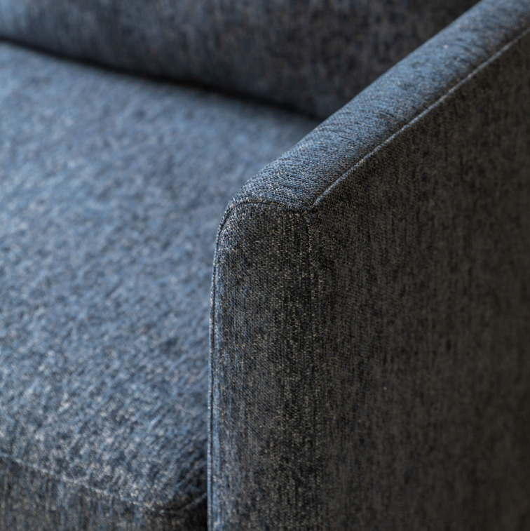 Close-up of Henley Charcoal fabric sofa showing the foam seat cushion, upholstered frame and turned wooden leg