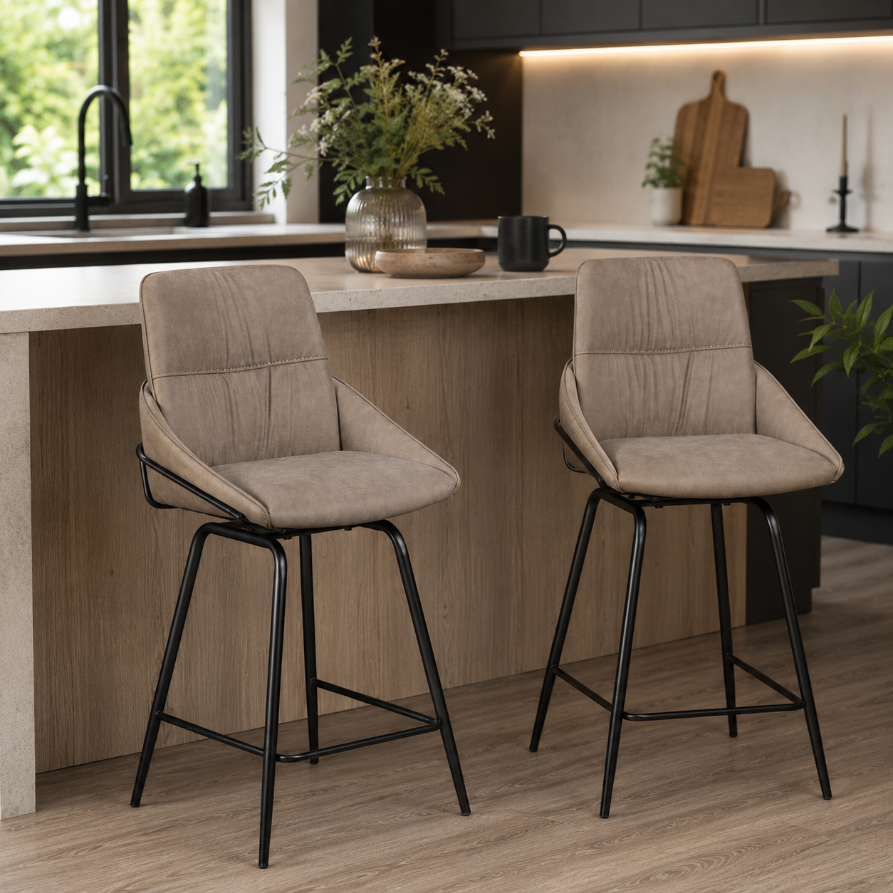 Two upholstered bar stools with beige fabric seats and black metal legs, shown in a modern kitchen setting.