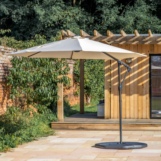 3m cream cantilever garden parasol in a landscaped garden