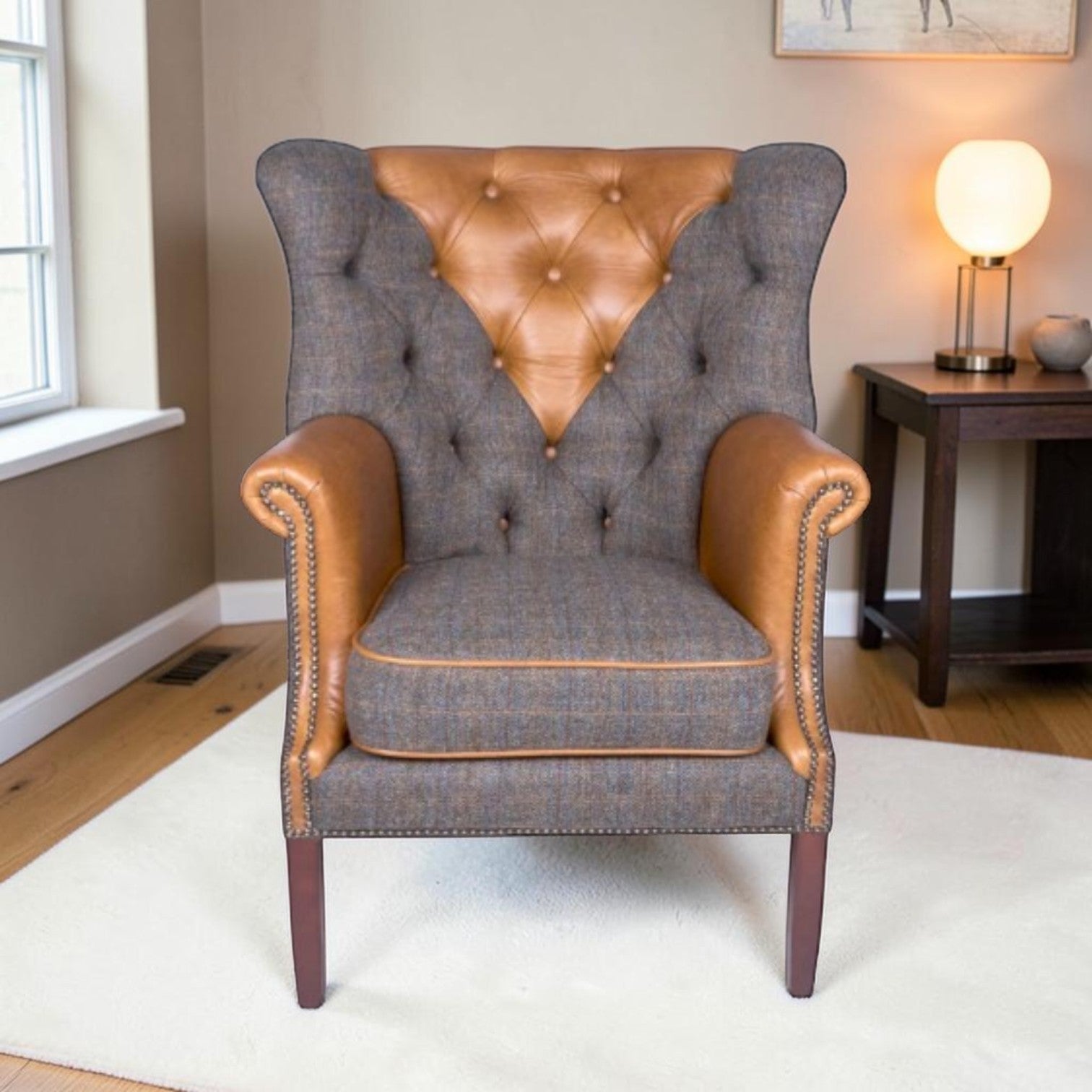 A classic wingback armchair with a Uist Harris Tweed body and Cerato tan leather panels on the backrest and armrests, styled in a cosy living room setting.