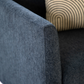 Close-up of Henley Charcoal fabric upholstered armrest with a Charcoal seat cushion and a beige patterned pillow in the background.