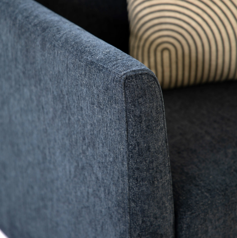 Close-up of Henley Charcoal fabric upholstered armrest with a Charcoal seat cushion and a beige patterned pillow in the background.