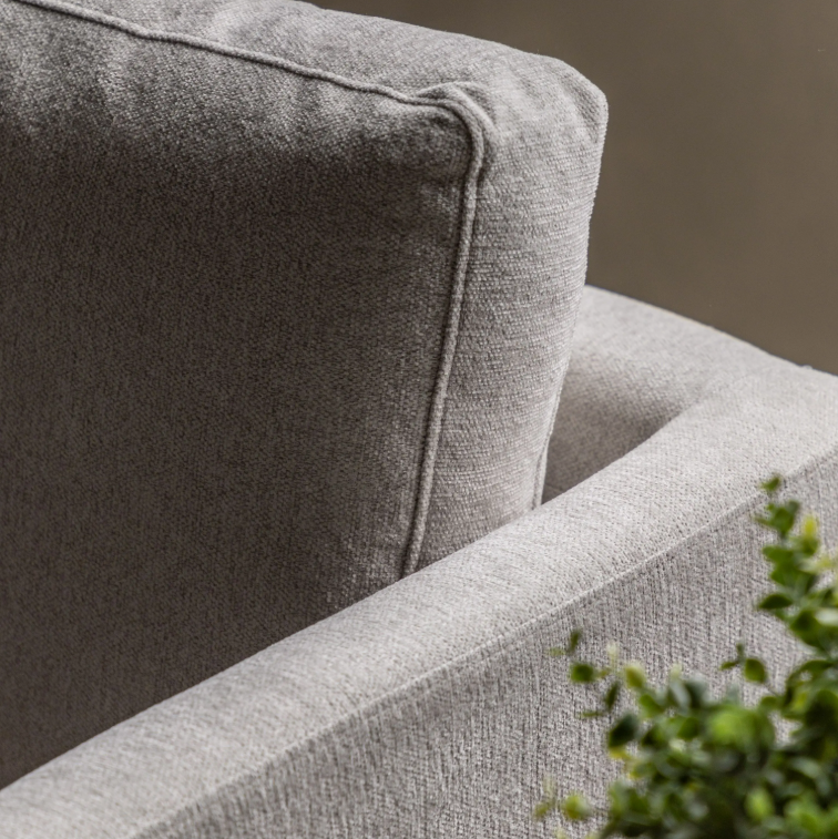 Close-up of Henley armrest and back cushion upholstered in Natural fabric with a blurred background