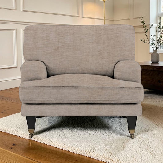 A light beige upholstered armchair with dark legs, shown in a styled living room setting on a white shag rug.