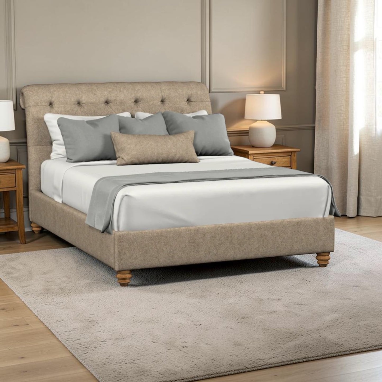 A upholstered bed frame with a tufted headboard and matching footboard, shown in a styled bedroom setting with white bedding, gray pillows, bedside tables, lamps, curtains, and a light rug.