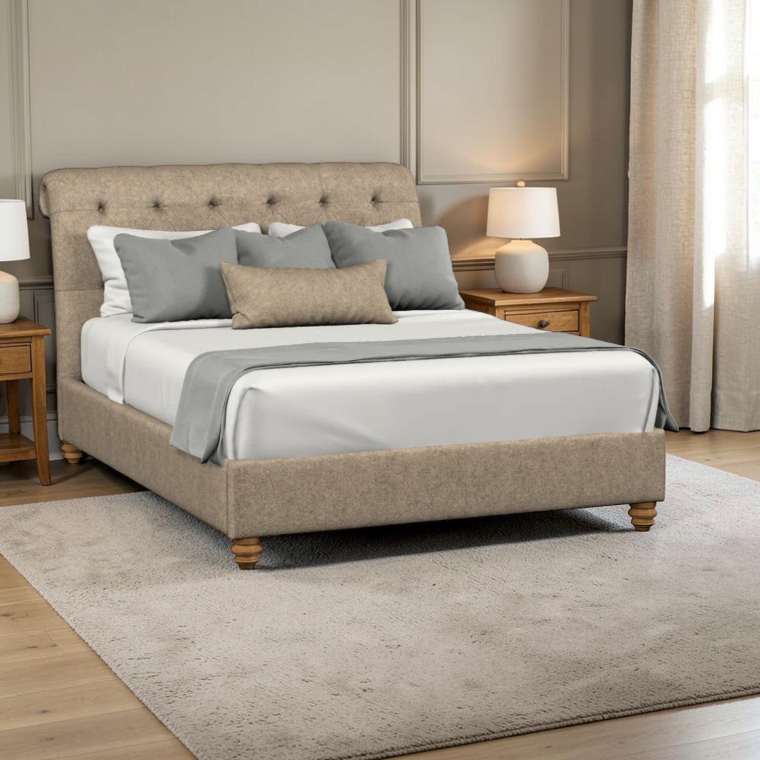 A upholstered bed frame with a tufted headboard and matching footboard, shown in a styled bedroom setting with white bedding, gray pillows, bedside tables, lamps, curtains, and a light rug.