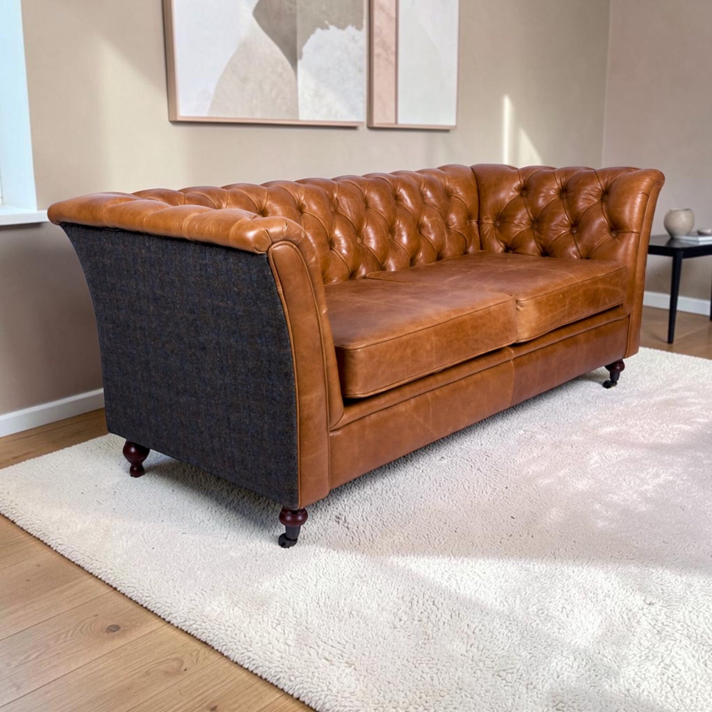 A Chesterfield-style sofa with Cerato brown leather tufted upholstery and Uist Harris Tweed, shown in a living room setting on a white rug.