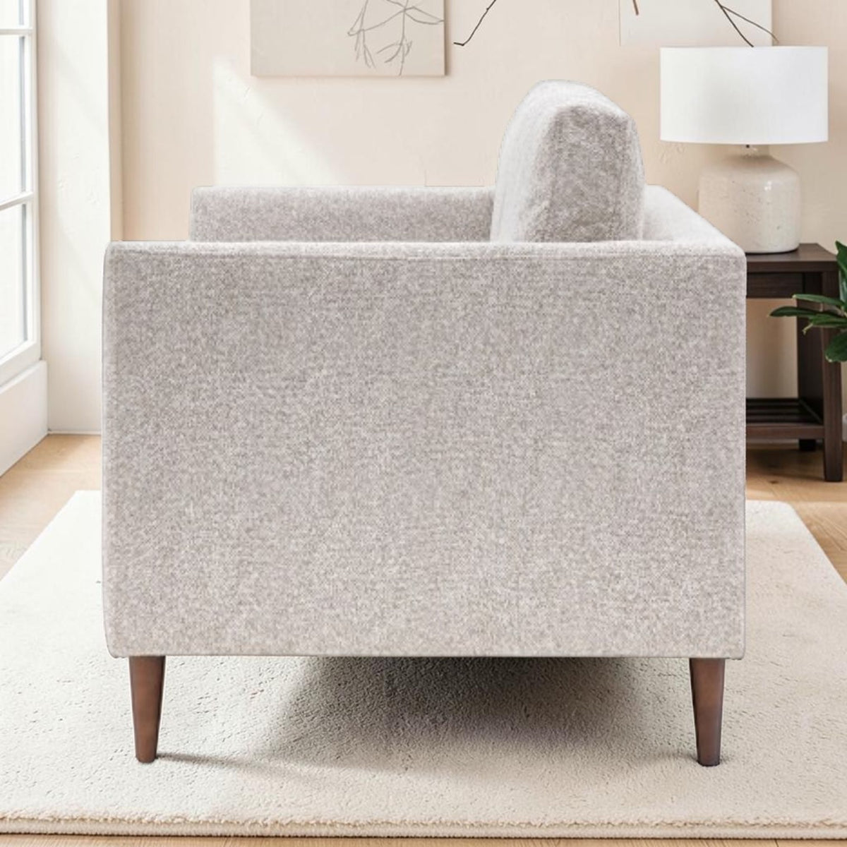 Henley sofa in Natural fabric showing the slim tapered arm, upholstered side and wooden legs