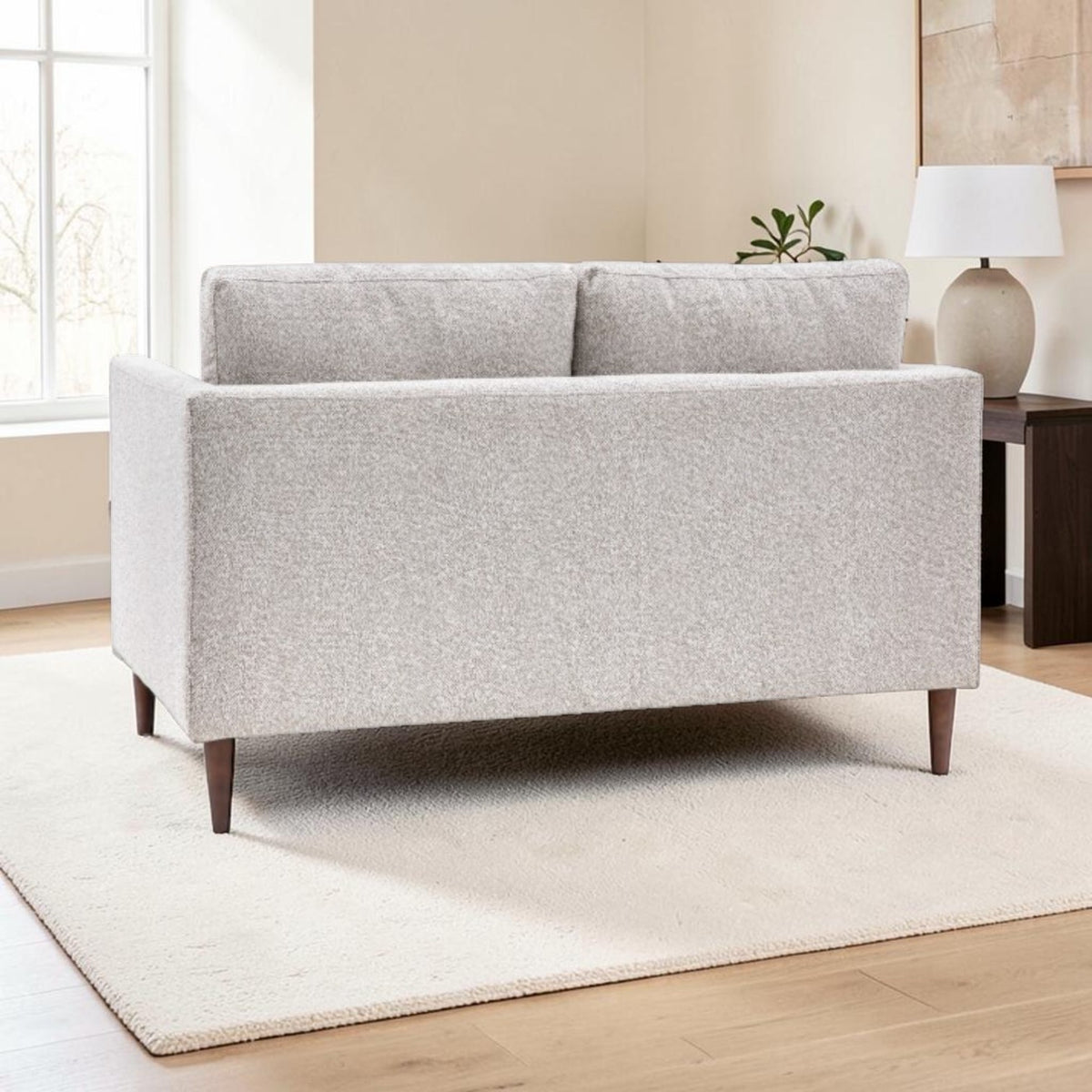 Henley sofa in Natural fabric showing the fully upholstered back and tapered wooden legs