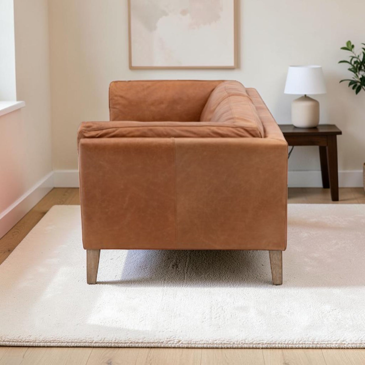 Side view of Hampton leather sofa showing the distinctive flared padded arm and tapered ash legs
